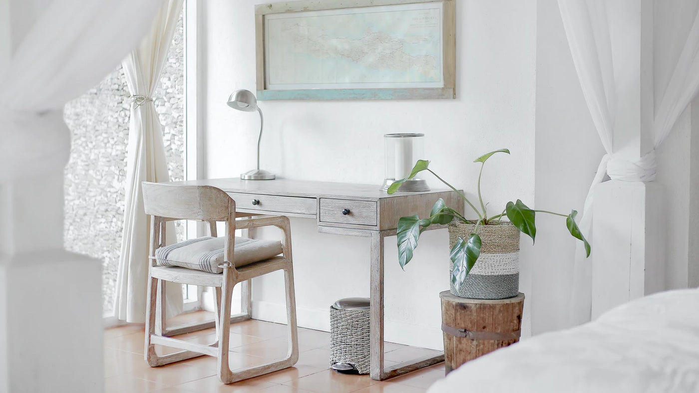A modern, white bright home office design with a wooden desk, lamp and chair
