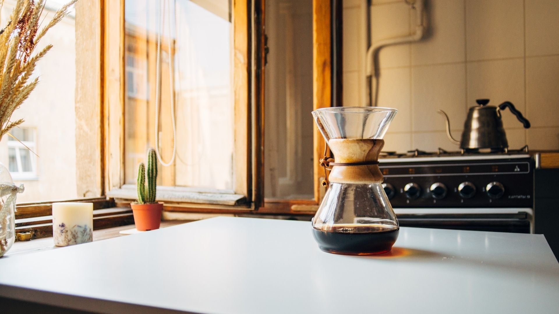 Apartment kitchen with candle in the window and coffee on the table